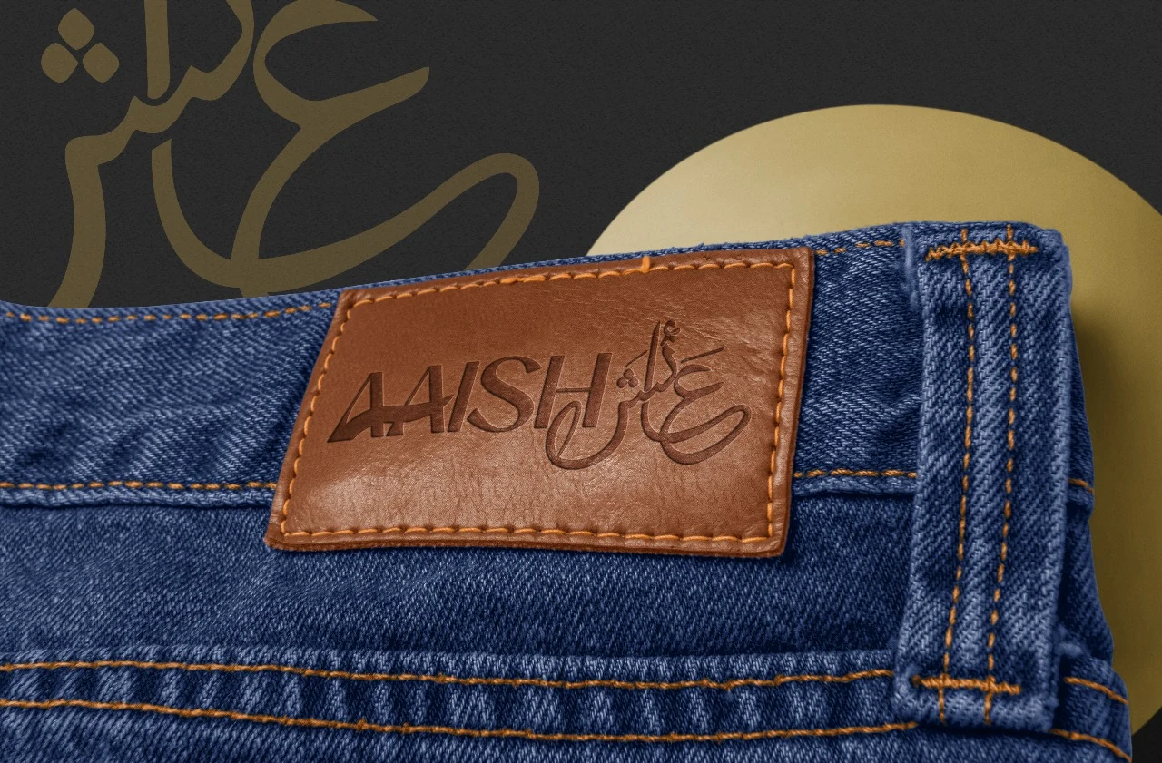 Aaish embossed denim leather patch with precision contrast stitching on raw denim